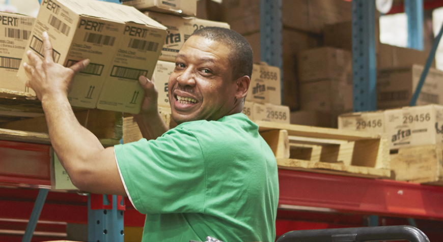 Warehouse employee pulling goods off shelf