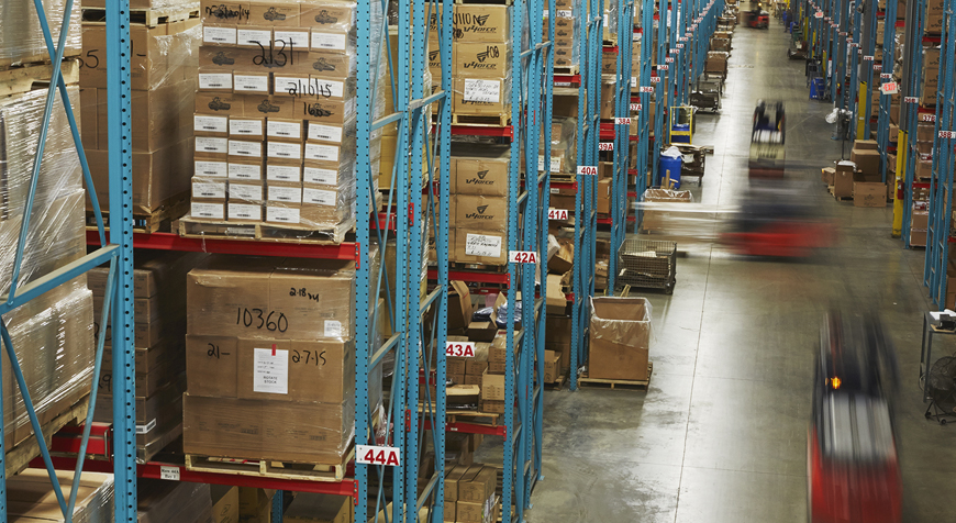 Warehouse shelving with forklifts in motion